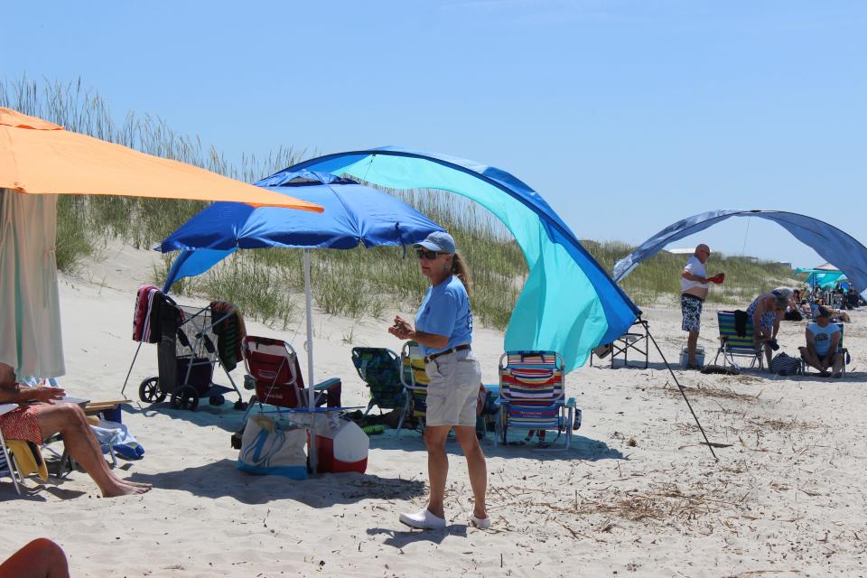 Cynthia Grant talks with a beachgoer about the town's ordinances that protect the dunes.