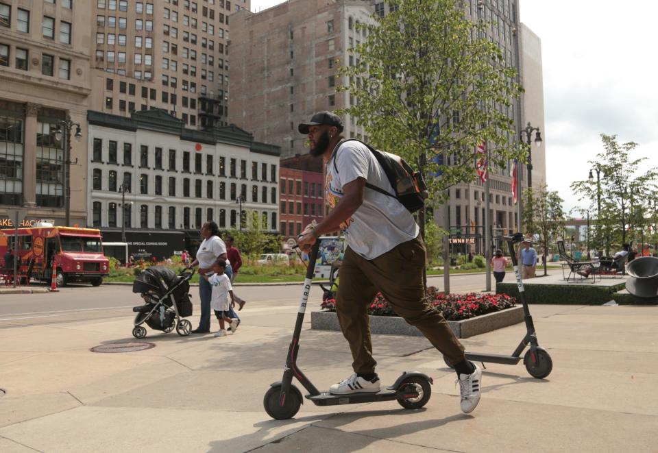 Cj Edwards, of Detroit, rents a Bird electric scooter to leave for lunch near Campus Martius in downtown Detroit in 2018.