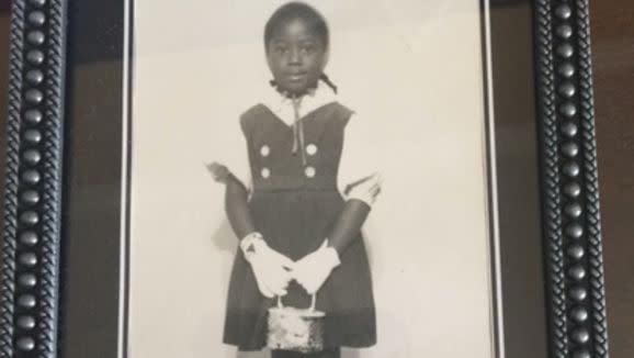 A childhood photo shows a young Trilby Barnes smiling and holding a purse.&nbsp; (Photo: Trilby Barnes/Charlene Dukes)