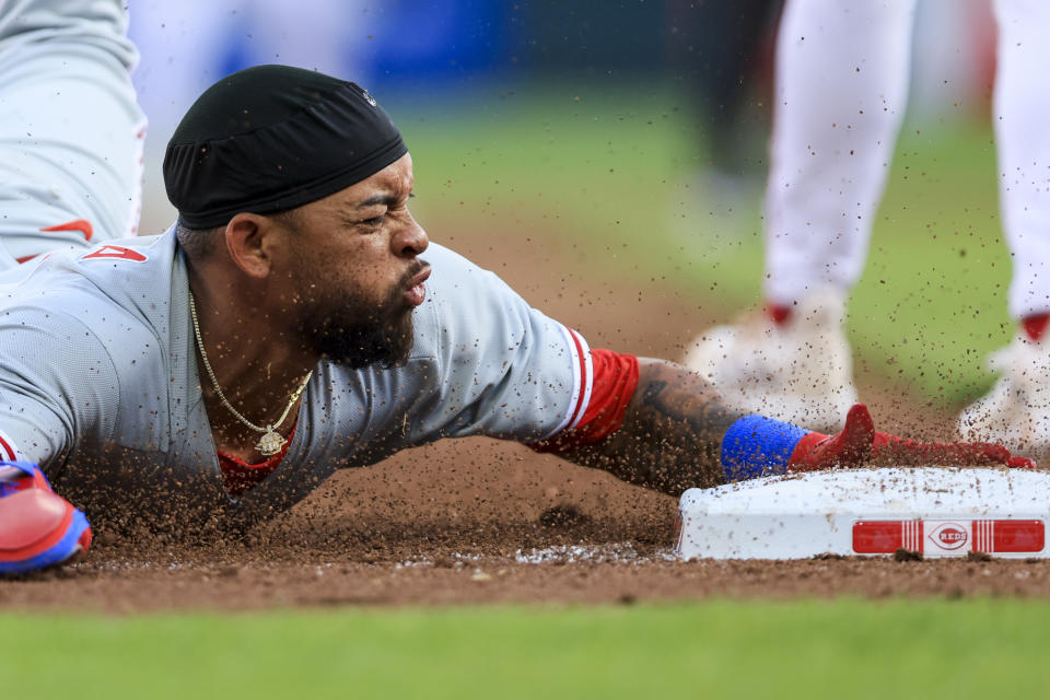 Philadelphia Phillies' Edmundo Sosa slides safely into third base after a single by Cristian Pache during the first inning of a baseball game against the Cincinnati Reds in Cincinnati, Thursday, April 13, 2023. (AP Photo/Aaron Doster)