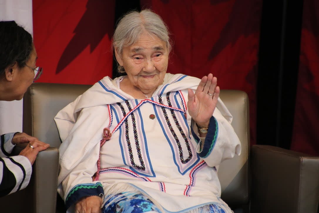 Inuk elder Qapik Attagutsiak waves to the crowd gathered at the Canadian History Museum in Gatineau, Que., to honour her contributions to the Second World War. (Olivia Stefanovich/CBC - image credit)