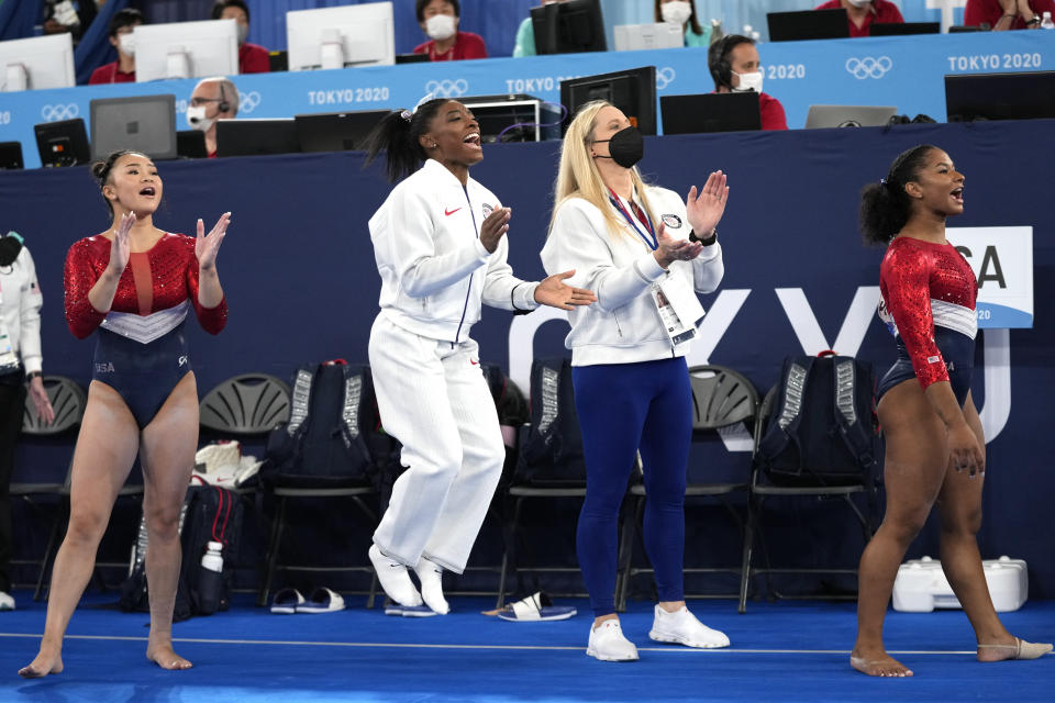 FILE - In this July 27m 2021 file photos, gymnasts from the United States, Simone Biles, center, Jordan Chiles , right, and Sunisa Lee cheer Grace McCallum as she performs on the floor during the artistic gymnastics women's final at the 2020 Summer Olympics, in Tokyo. Biles and Naomi Osaka are prominent young Black women under the pressure of a global Olympic spotlight that few human beings ever face. But being a young Black woman -- which, in American life, comes with its own built-in pressure to perform -- entails much more than meets the eye. (AP Photo/Ashley Landis, File)