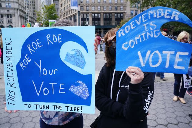 New York City demonstrators hold signs saying, 