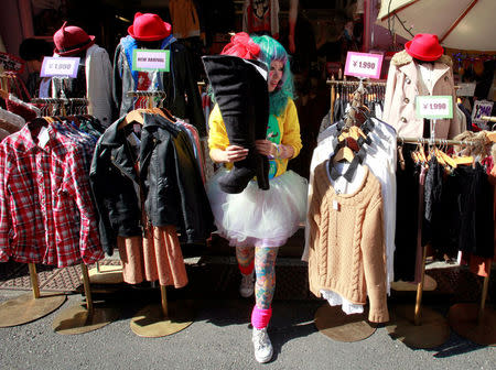A store clerk brings out a pair of boots for a customer in Tokyo's Harajuku shopping district October 26, 2012. REUTERS/Yuriko Nakao/File Photo