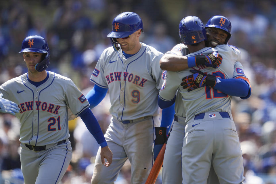 New York Mets' Starling Marte celebrates with Francisco Lindor (12) after hitting a home run during the sixth inning of a baseball game against the Los Angeles Dodgers in Los Angeles, Saturday, April 20, 2024. Zack Short (21) and Brandon Nimmo (9) also scored. (AP Photo/Ashley Landis)