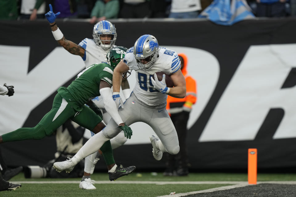 Detroit Lions tight end Brock Wright (89) carries the ball into the end zone against New York Jets cornerback D.J. Reed (4) for a touchdown during the fourth quarter of an NFL football game, Sunday, Dec. 18, 2022, in East Rutherford, N.J. (AP Photo/Bryan Woolston)