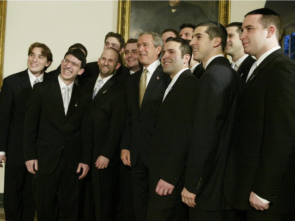 President George W. Bush poses with members of the Kol Zimra a cappella choir in 2004.
