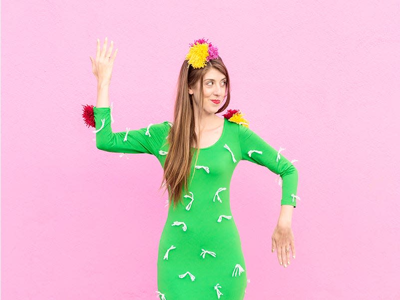 A woman wears a green dress with yarn attached as a cactus costume