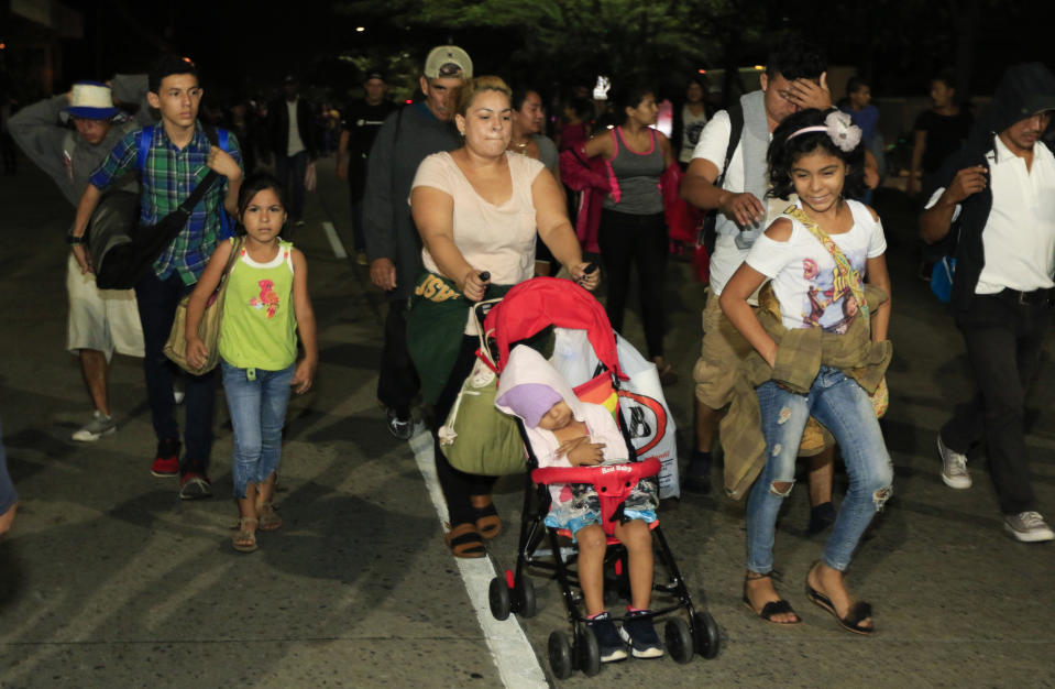 Migrantes caminan por una ruta desde San Pedro Sula, Honduras, antes del amanecer del miércoles 15 de enero de 2020, con la esperanza de formar una caravana hacia el lejano Estados Unidos. (AP Foto/Delmer Martinez)