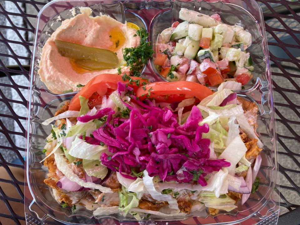 One of Shawarma Brothers' best sellers: the chicken shawarma bowl — a bed of rice stacked with chicken shawarma, lettuce, sliced tomatoes, purple cabbage, sumac onions and pickled turnips — is served with hummus, pickles and a salad.
