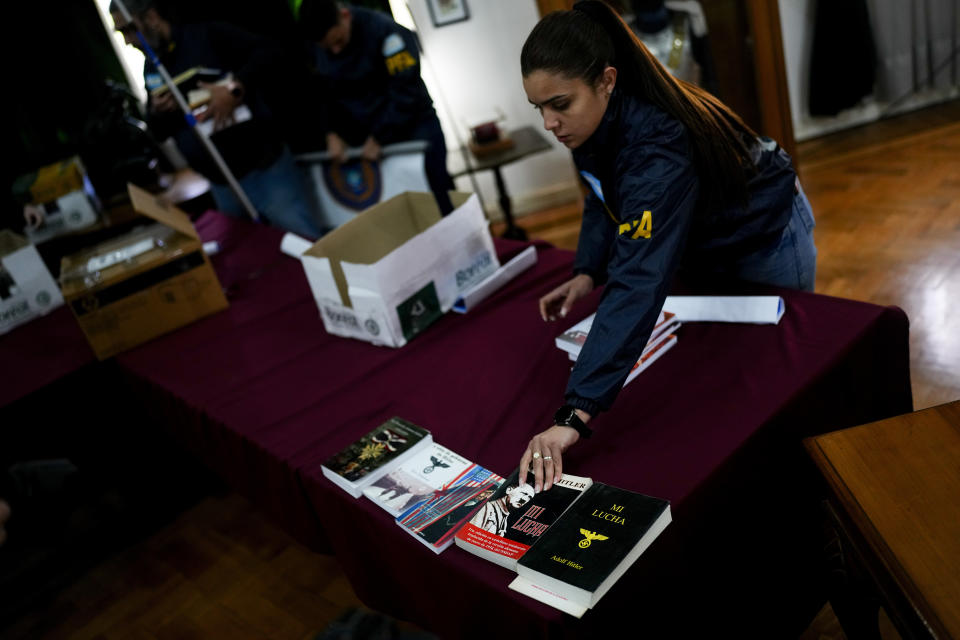 Agentes federales colocaron libros incautados dentro de cajas después de exhibirlos a la prensa en la sede de la Policía Federal en Buenos Aires, Argentina, el miércoles 13 de septiembre de 2023. (AP Foto/Natacha Pisarenko)