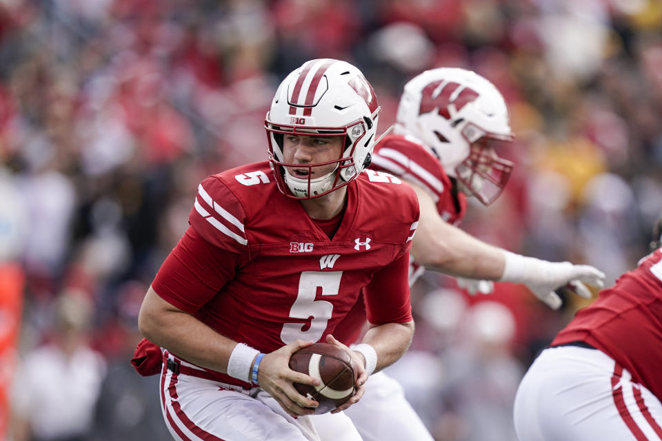 Wisconsin quarterback Graham Mertz (5) handles a snap during the first half of an NCAA college football game against Iowa, Saturday, Oct. 30, 2021, in Madison, Wis. Wisconsin upset Iowa 27-7. (AP Photo/Andy Manis)