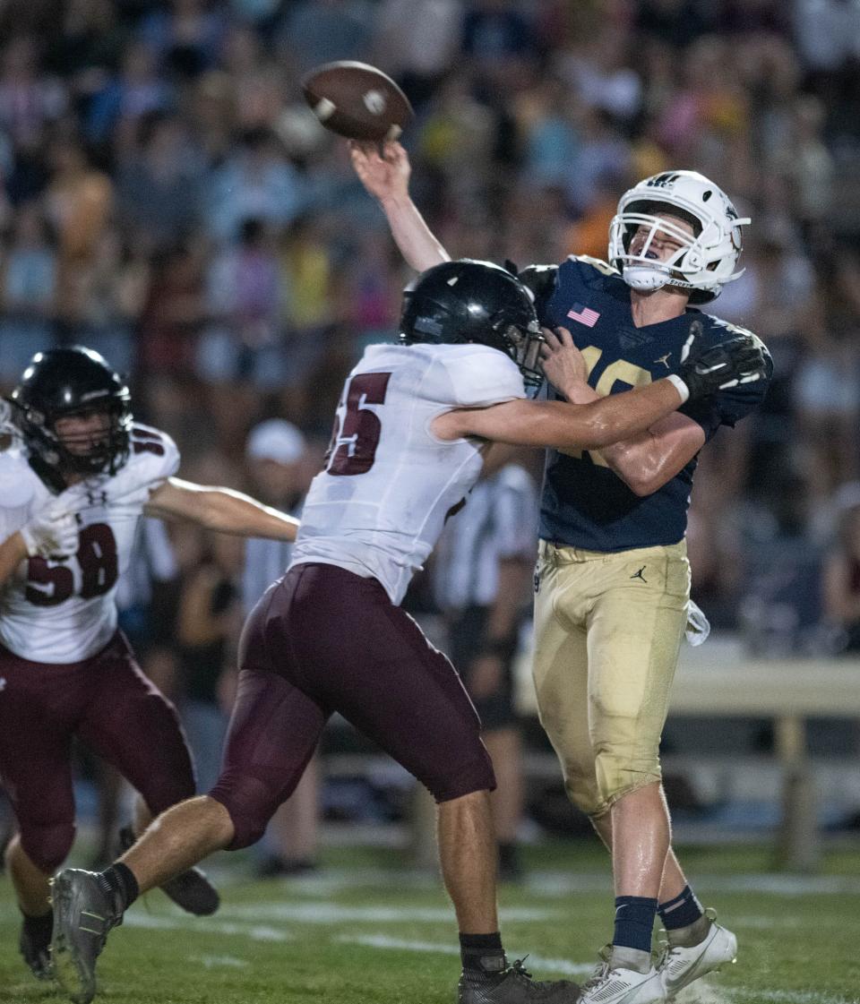 Quarterback Battle Alberson (18) gets the pass off under pressure during the Navarre vs Gulf Breeze spring football game at Gulf Breeze High School on Friday, May 19, 2023.