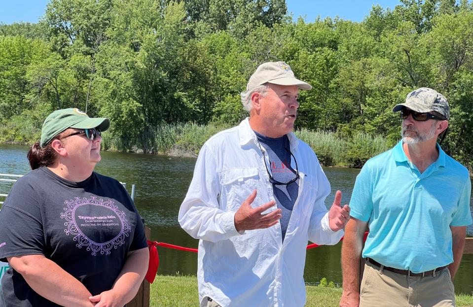Charles Wooley, the U.S. Fish & Wildlife Service Great Lakes Region director, speaks at a program on Aug. 2, concerning the improvements made to the Oconto Sportsmen's Club's public fishing area on the Oconto River. At left is Nicole Rommel of the Oneida Nation and at right Jim Zellmer of the Wisconsin Department of Natural Resources. Along with the Menominee Tribe, the entities are the trustees of the NRDA, which provided nearly half of the funding for the project.