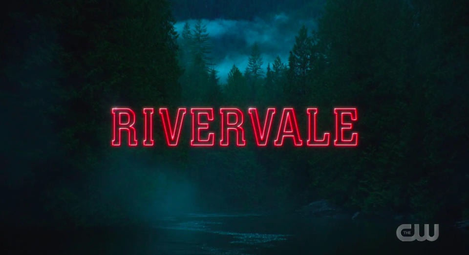 A TV series title screen, with the word 'Rivervale' in the centre, in red capital letters. Behind it is a forest surrounding a river, with a dark sky in the background