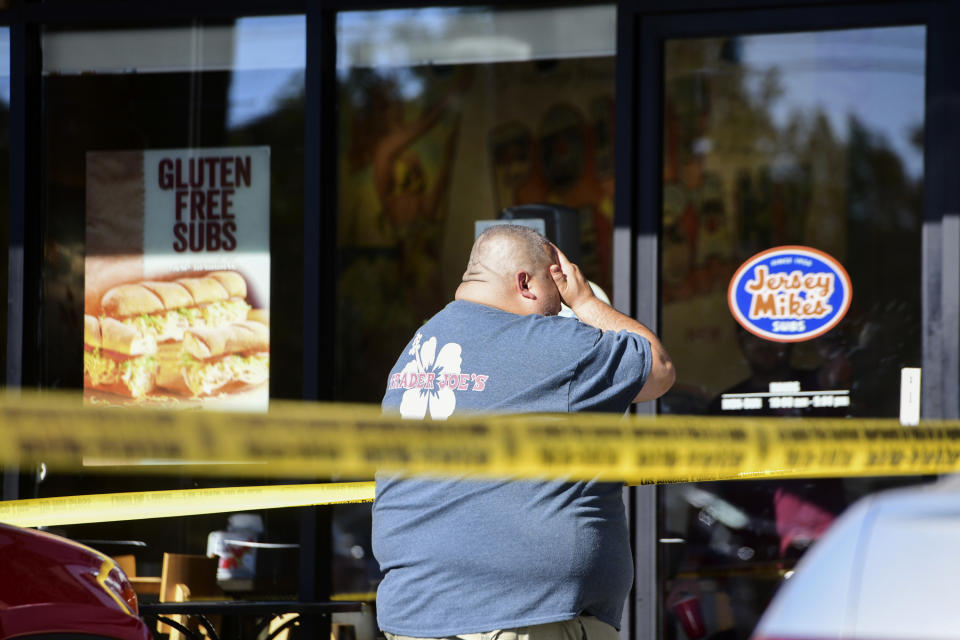 <p>A Trader Joe’s employee is distraught as he recounts his experience just outside the store where a man held employees hostage and killed one woman in L.A. on Saturday. (Photo: Christian Monterosa via AP) </p>