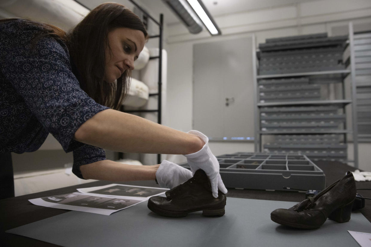 Elzbieta Cajzer, head of the museum's collections department, shows a shoe that belonged to Vera Vohryzkova, a child victim of the former Nazi German death camp Auschwitz-Birkenau at the conservation laboratory on the grounds of the camp in Oswiecim, Poland, Wednesday, May 10, 2023. Vera was born Jan. 11, 1939, into a Jewish Czech family and was sent to Auschwitz in a transport from the Theresienstadt ghetto in 1943 with her mother and brother. Her father Max Vohryzek was sent in a separate transport. They all perished. (AP Photo/Michal Dyjuk)