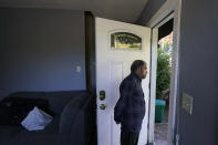 Abdul, who worked as a mechanic before he left Kabul, Afghanistan with his family about a month ago, looks out the doorway of a rental house, Thursday, Sept. 16, 2021, where his family have been provided a place to stay in Seattle. The home is owned by Thuy Do, who was nine years old when her family arrived in the United States from Vietnam in the 1980s. Now Do and her husband have offered their vacant rental home to refugee resettlement groups to house newly arriving Afghans in need of a place to stay. (AP Photo/Ted S. Warren)