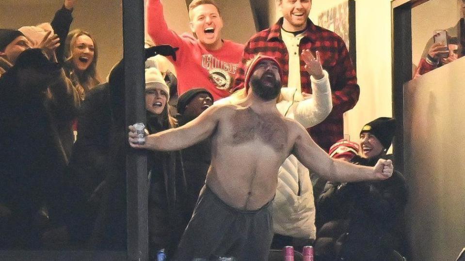 A shirtless Jason Kelce watching his brother Travis play against Buffalo