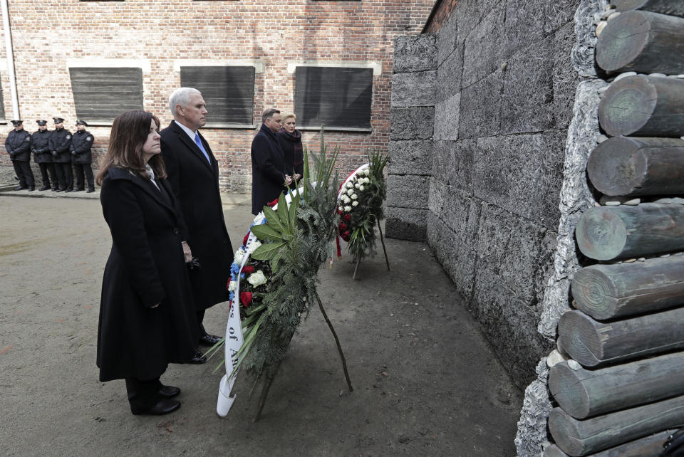 United States Vice President Mike Pence and his wife Karen Pence, left, stand with Poland's President Andrzej Duda and his wife Agata Kornhauser-Duda, right, in front of wreaths at a death wall during their visit at the Nazi concentration camp Auschwitz-Birkenau in Oswiecim, Poland, Friday, Feb. 15, 2019. (AP Photo/Michael Sohn)