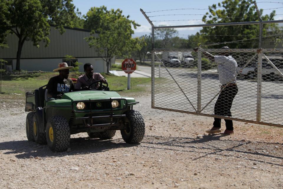 Workers ride out of the gate of the Christian Aid Ministries headquarters in Titanyen, north of Port-au-Prince, Haiti, Monday, Dec. 6, 2021. The religious group based in Ohio said that three more hostages were released on Sunday, while another 12 remain abducted in Haiti. The group provided no further details.