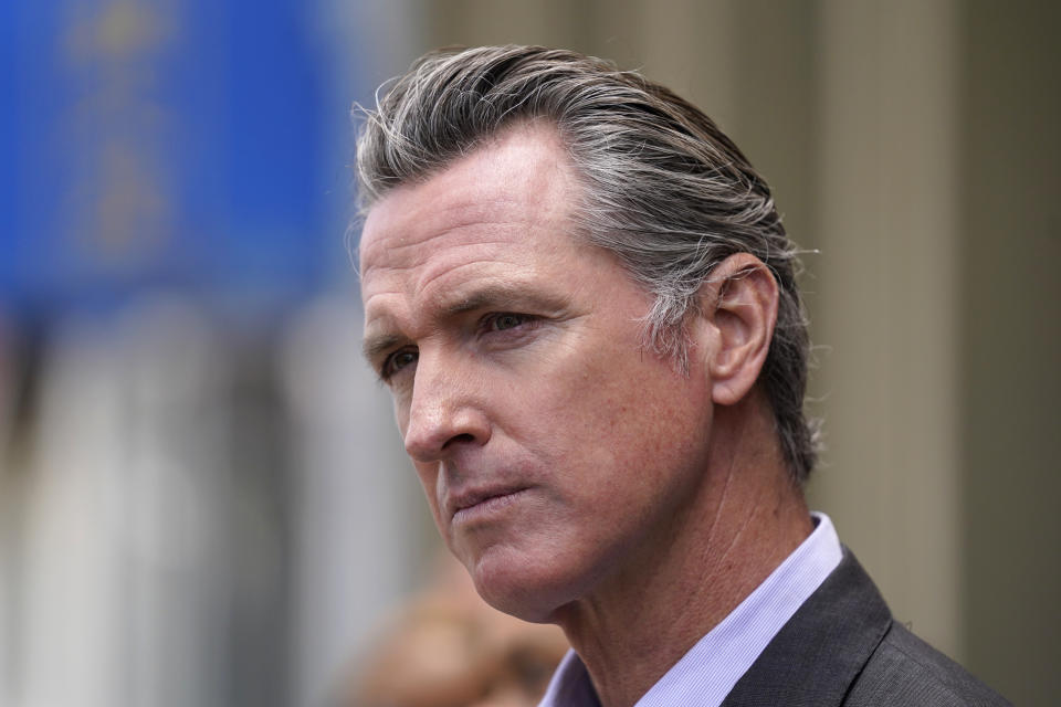 FILE - In this June 3, 2021 file photo, California Gov. Gavin Newsom listens to questions during a news conference outside a restaurant in San Francisco While governors across the country are ending all or most of their coronavirus restrictions, many of them are keeping their pandemic emergency orders in place. Those orders allow them to restrict public gatherings and businesses, mandate masks, sidestep normal purchasing rules, tap into federal money and deploy National Guard troops to administer vaccines. (AP Photo/Eric Risberg, File)