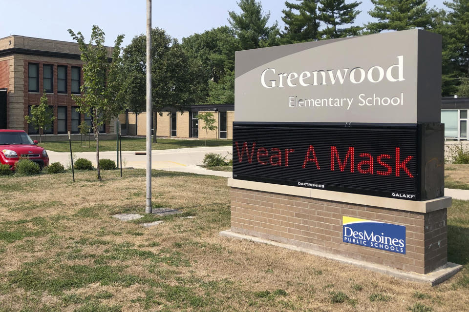 FILE - In this Sept. 17, 2020 file photo, a sign outside of Greenwood Elementary School promotes mask-wearing in Des Moines, Iowa. With COVID-19 cases soaring nationwide, school districts across the U.S. are yet again confronting the realities of a polarized country and the lingering pandemic as they navigate mask requirements, vaccine rules and social distancing requirements for the fast-approaching new school year. (AP Photo/Scott McFetridge, File)