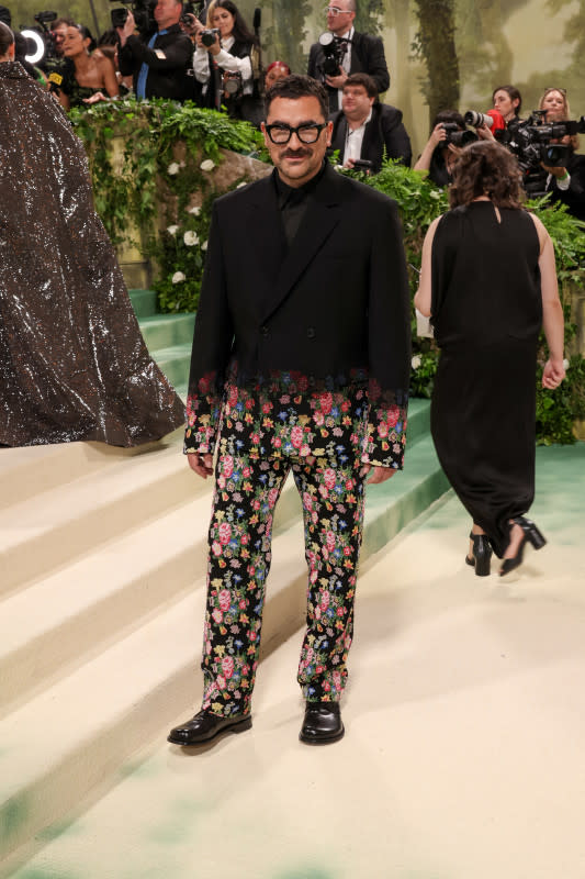 <p>John Shearer/Getty Images</p><p>The <em>Schitt's Creek</em> star wore a black suit the bottom of which was detailed with flowers. </p>