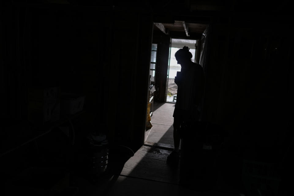 Jacquelyn Velazquez looks at water dripping through the damaged roof onto the floor of her family's gutted home during a rain shower, in Fort Myers Beach, Fla., Wednesday, May 24, 2023. "It's, you know, it's in the snap of the finger. Your life is never going to be the same," said Velazquez. "It was very mentally traumatic. It's not the things that you lose. It's just trying to get back to some normalcy." (AP Photo/Rebecca Blackwell)