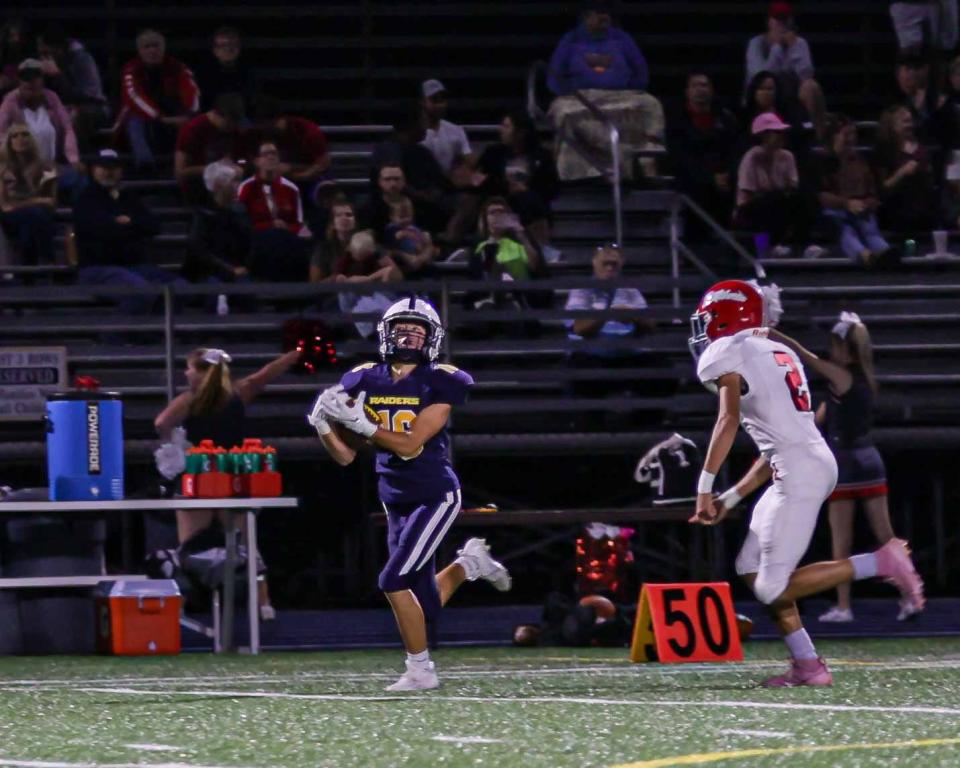 Sara Miller (16) hauls in a rare deep pass as Cash Watson (2) defends. The ELCO Raiders played host to their cross county rival Annville-Cleona Dutchmen. August 31, 2023. The Raiders defeated the Dutchmen 49-7.