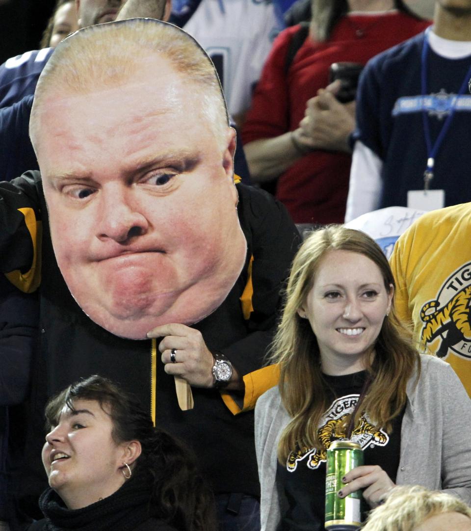 A Hamilton Tiger Cats fan holds a cut out poster of Toronto Mayor Rob Ford during the CFL eastern final football game between the Toronto Argonauts and the Hamilton Tiger Cats in Toronto, November 17, 2013. REUTERS/Fred Thornhill (CANADA - Tags: SPORT FOOTBALL)