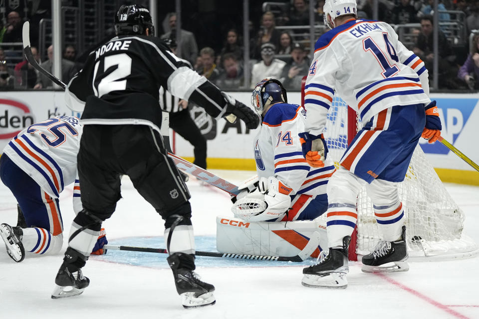 Los Angeles Kings left wing Trevor Moore (12) scores on Edmonton Oilers goaltender Stuart Skinner (74) as defenseman Mattias Ekholm (14) watches during the third period in Game 3 of an NHL hockey Stanley Cup first-round playoff series Friday, April 21, 2023, in Los Angeles. (AP Photo/Mark J. Terrill)