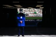 A masked security guard stands in front an entrance of the National Stadium, venue of the upcoming Olympics, in Tokyo on February 28, 2020. - The International Olympic Committee is "committed" to holding the 2020 Games in Tokyo as planned despite the widening new coronavirus outbreak, the body's president has pledged. (Photo by CHARLY TRIBALLEAU / AFP) (Photo by CHARLY TRIBALLEAU/AFP via Getty Images)