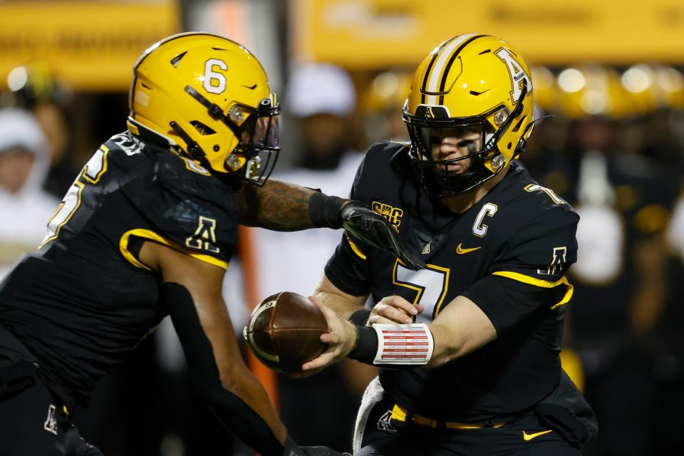 Appalachian State quarterback Chase Brice, right, hands off to running back Camerun Peoples (6) during a game against Georgia State on Oct. 19, 2022, in Boone, N.C. Appalachian State won 42-17.