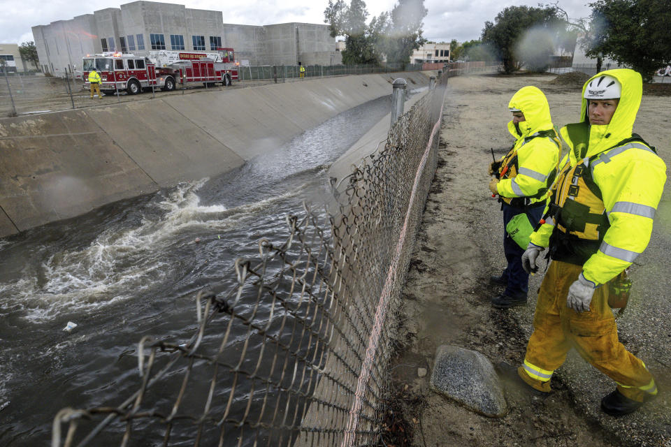 Firefighters look for people trapped in the rain-swollen Cucamonga wash in Ontario, Calif., on Tuesday, Nov. 8, 2022. (Watchara Phomicinda/The Orange County Register via AP)