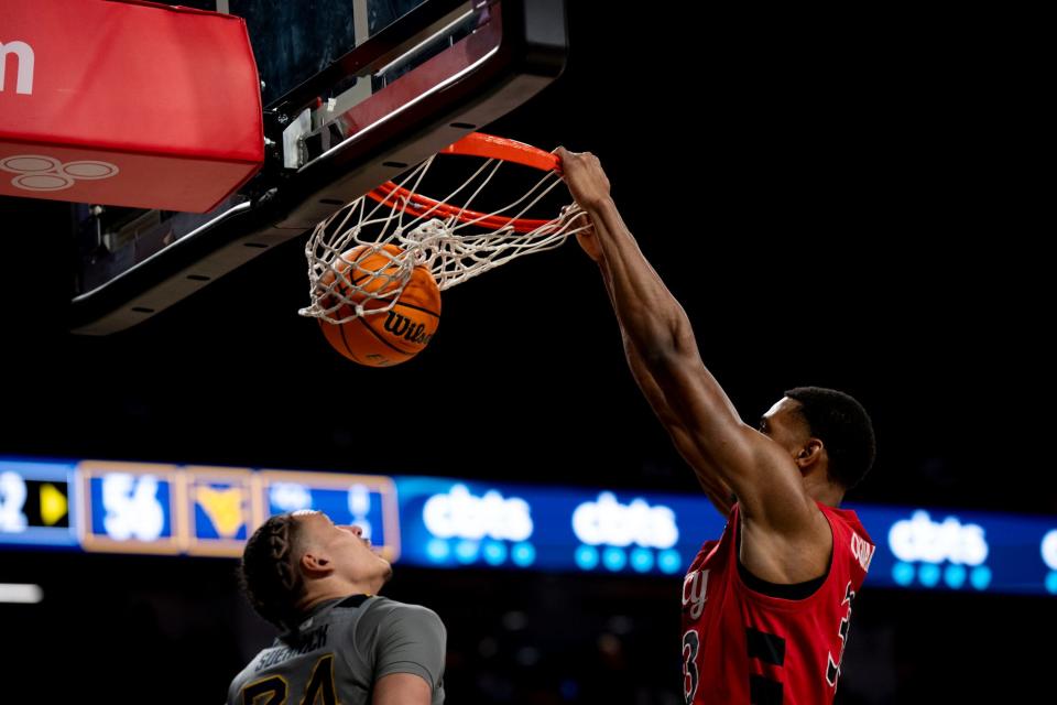 Ody Oguama gets a throwdown over West Virginia's Patrick Suemnick in UC's Senior Day victory Saturday.