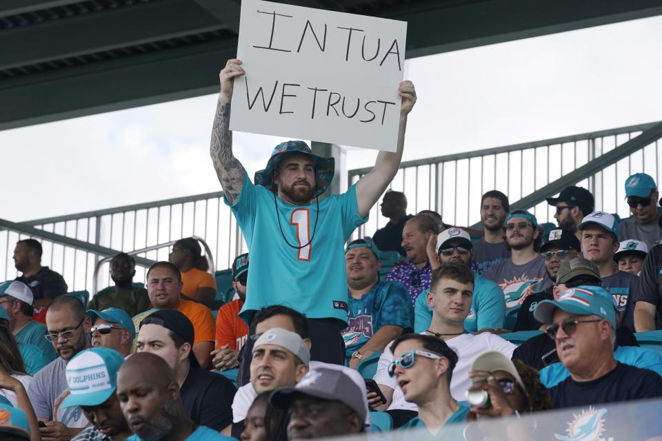 A Dolphins fan holds up a sign supporting quarterback Tua Tagovailoa during Saturday's practice in Miami Gardens.