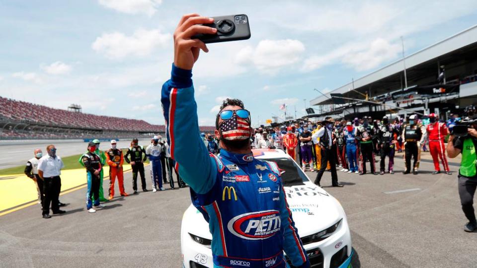 Driver Bubba Wallace takes a selfie with himself and other drivers that pushed his car to the front in the pits of the Talladega Superspeedway prior to the start of the NASCAR Cup Series auto race at the Talladega Superspeedway in Talladega Ala., Monday.