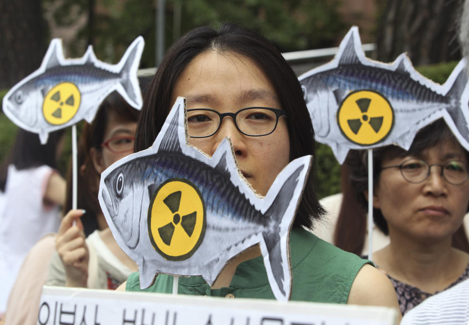 FILE - In this Aug. 1, 2013 file photo, environmentalists stage a rally denouncing imported agricultural and marine products from Japan without radioactivity test in front of the Japanese Embassy in Seoul. South Korea on Friday, April 12, 2019, welcomed the decision and said it will continue to block all fishery products from Fukushima and seven neighboring prefectures to ensure "only foods that are confirmed as safe are put on the table." (AP Photo/Ahn Young-joon, File)