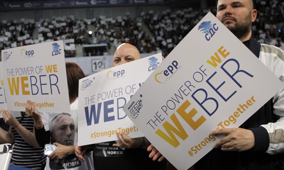Supporters of ruling GERB party hold banners reading "Weber" as Germany's Manfred Weber of the European People's Party addresses the audience party's rally in Sofia, Bulgaria, Sunday, May 19, 2019. The rally comes days before more than 400 million Europeans from 28 countries will head to the polls to choose lawmakers to represent them at the European Parliament for the next five years. (AP Photo/Valentina Petrova)