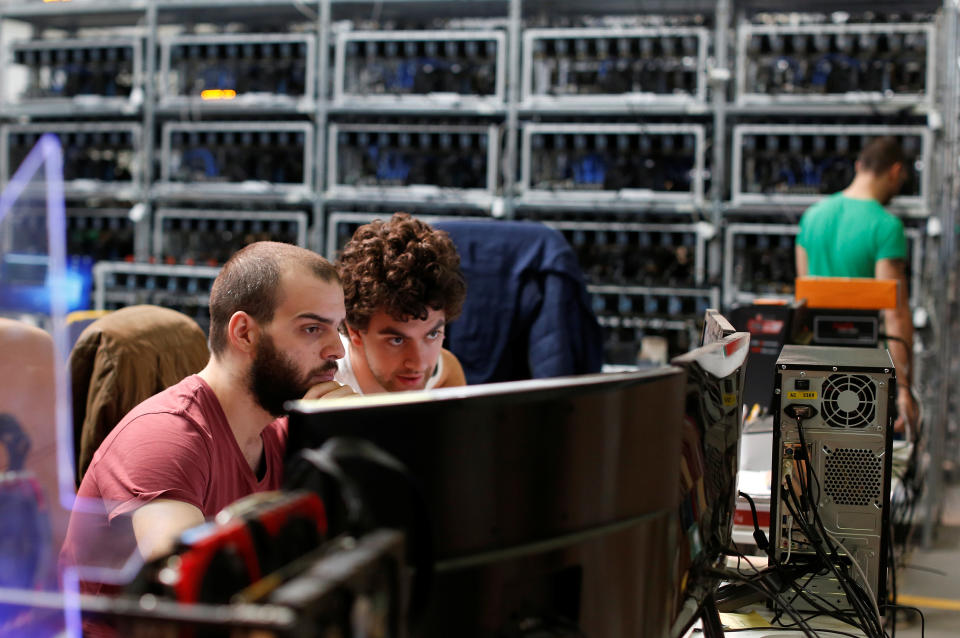 Employees work on bitcoin mining computers at Bitminer Factory in Florence, Italy