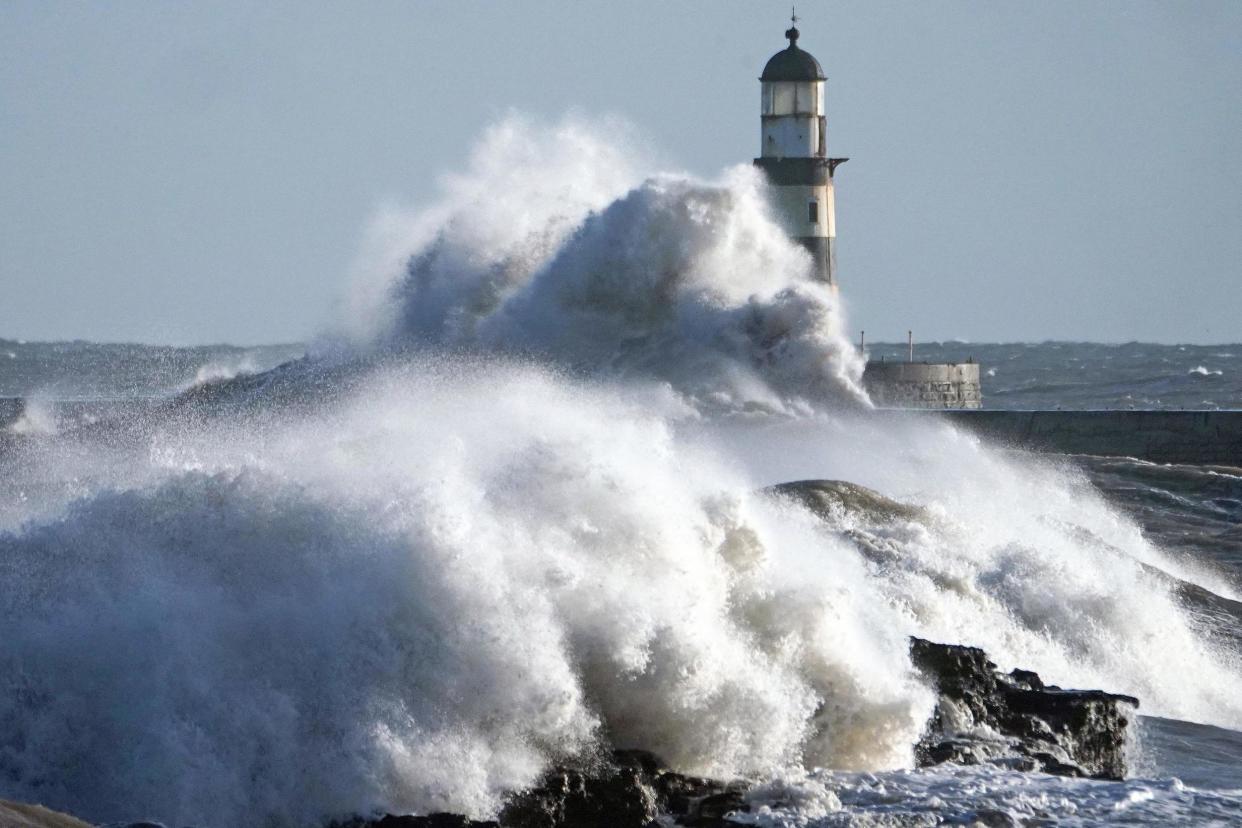 Waves crash against the pier wall at Seaham Lighthouse on the County Durham coast: PA