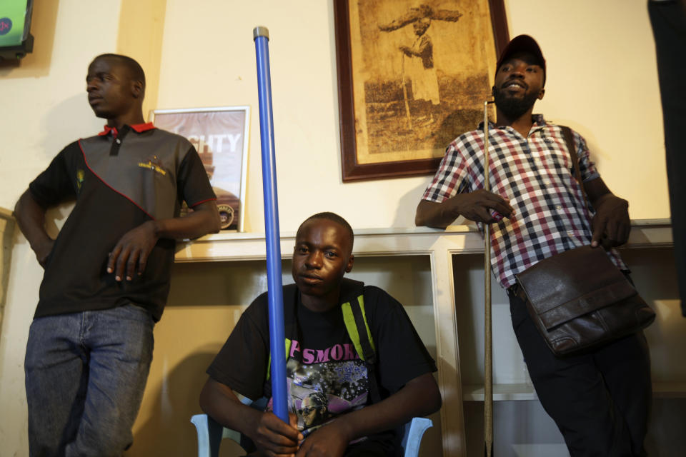 Levite Chisakarire, centre, 18 years old, waits for his turn to play pool on the outskirts of Harare, Zimbabwe, Saturday, Nov, 19, 2022.Unable to further his education after finishing high school with low grades in 2019, Chisakarire struggled to find a job in Zimbabwe's stressed industries. Previously a minority and elite sport in Zimbabwe, the game has increased in popularity over the years, first as a pastime and now as a survival mode for many in a country where employment is hard to come by. (AP Photo/Tsvangirayi Mukwazhi)
