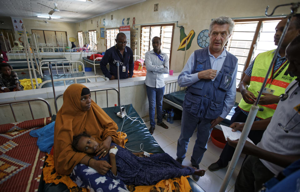 FILE - In this Tuesday, Dec. 19, 2017 file photo, U.N. refugee chief Filippo Grandi, center-right, visits a hospital as he tours Dadaab refugee camp, hosting over 230,000 inhabitants, in northern Kenya. An internal United Nations document obtained by The Associated Press on Friday, March 29, 2019 says Kenya again seeks to close the Dadaab camp that hosts more than 200,000 refugees from neighboring Somalia. (AP Photo/Ben Curtis, File)
