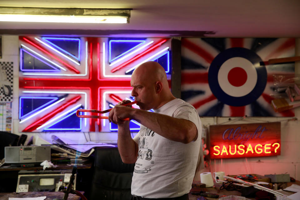 <p>Neon Bender Nick Ellwood blows into glass tubes to maintain their shape as he bends them while making neon artworks in God’s Own Junkyard workshop in Rainham in God’s Own Junkyard in London, Britain, May 17, 2017. (Photo: Russell Boyce/Reuters) </p>