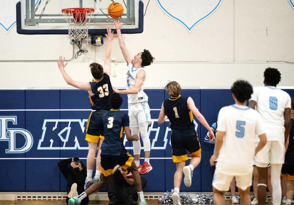 Downey’s Jayden Coelho scores on a layup over Turlock’s Peter Wilson (33) in the Central California Athletic League game at Downey High School in Modesto, Calif., Friday, Jan. 19, 2024.