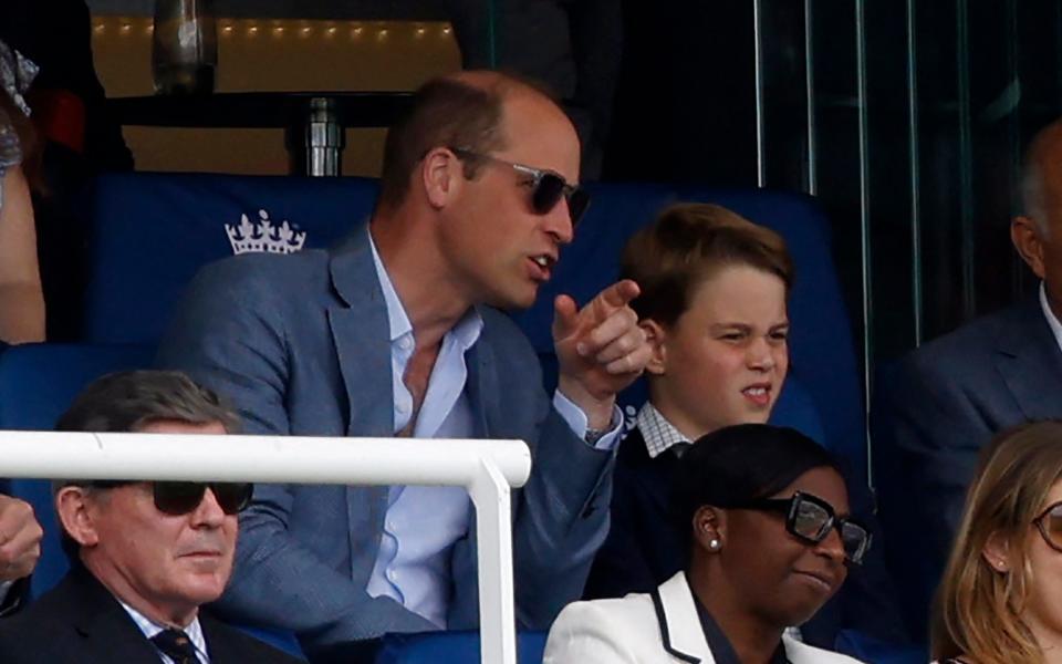 Prince William, Prince of Wales (L) and his son Britain's Prince George of Wales (R) watch the afternoon session