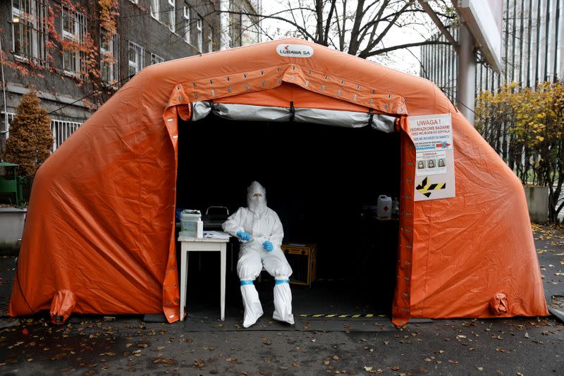 FILE PHOTO: A health worker in protective suit waits for people at a test center in Warsaw