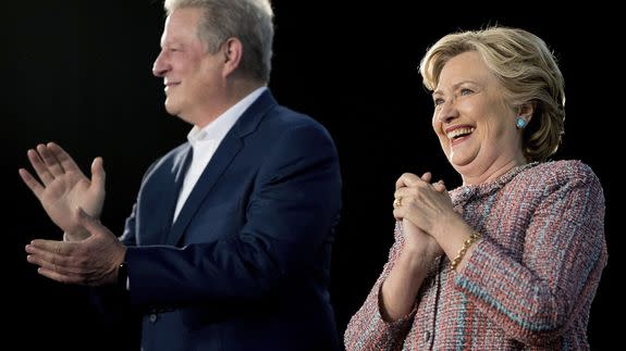Hillary Clinton, right, accompanied by former Vice President Al Gore, left, takes the stage for a rally in Miami, Tuesday, Oct. 11, 2016.