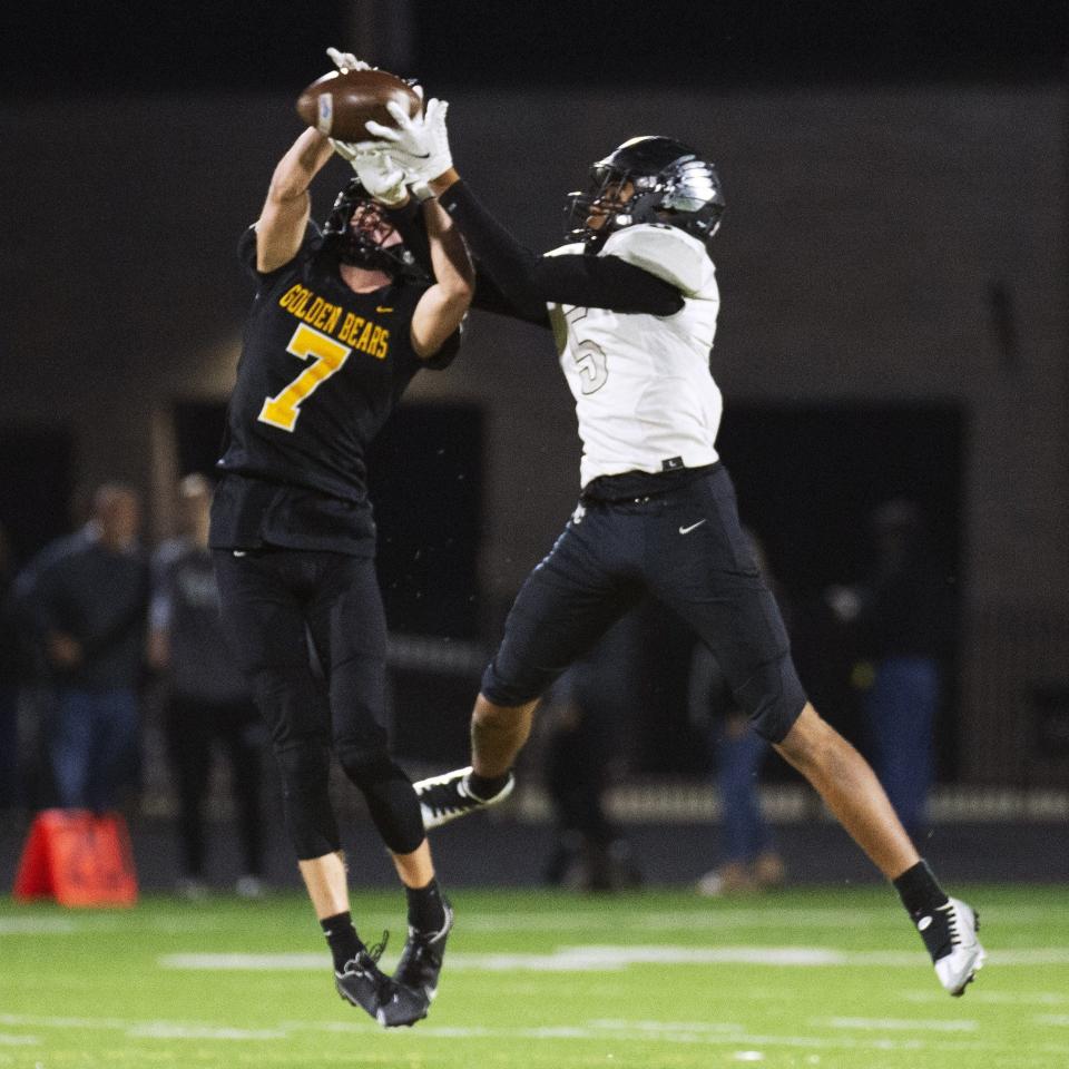 Upper Arlington defensive back Will Barger (7) fights for the interception against Westerville Central wide receiver Jacob Harris (5) in a Division I regional quarterfinal Nov. 4.